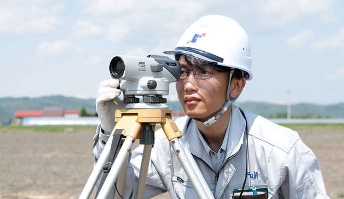 農業土木に向けた測量作業を行う職員